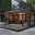 Foto Moderner, schwarzer Pop-Up Store in Container-Bauweise mit großen Glasfronten, Holzterrasse und hochwertiger Innenbeleuchtung für Retail-Zwecke in einem urbanen Umfeld.