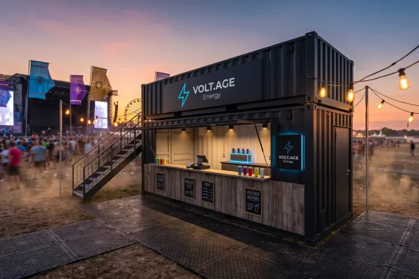 Getränke-Festivalcontainer „Volt.age“ – Eventmodul mit Dachterrasse - Foto Ein moderner, anthrazitfarbener Getränke-Festivalcontainer mit dem Branding „Volt.age“. Das Modul zeigt eine offene Verkaufsfront mit Holzelementen, LED-Akzenten und eine Treppe, die zur optionalen Dachterrasse führt. Im Hintergrund ein belebtes Festivalgelände bei Abenddämmerung.